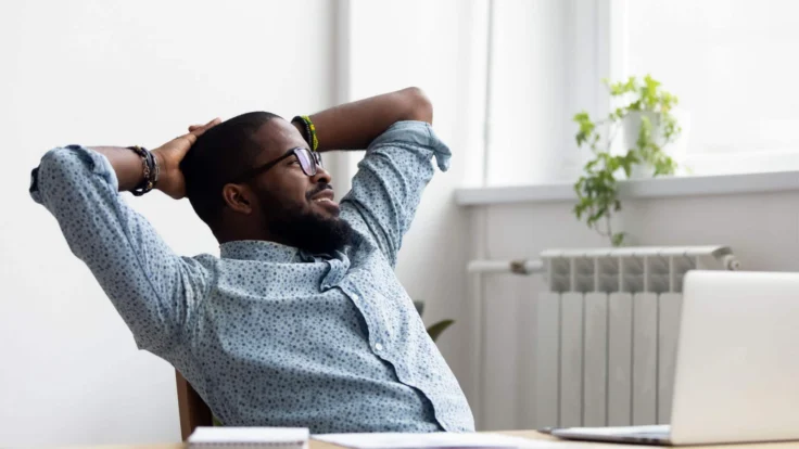 a man sitting at a desk in front of a laptop