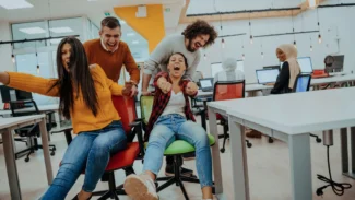 a group of people having fun around a table in an office