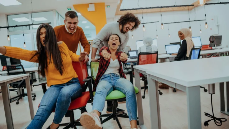 a group of people having fun around a table in an office