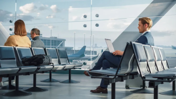 a man sitting on a bench using a laptop