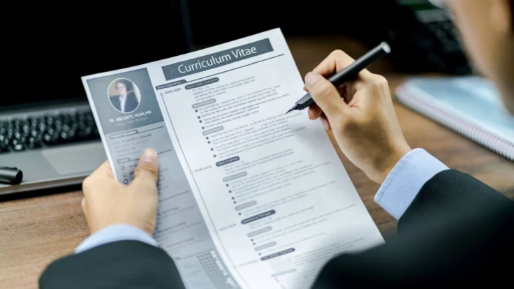a person sitting at a desk with a pen and paper.