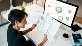 a woman sitting at a desk with an online portfolio on her computer