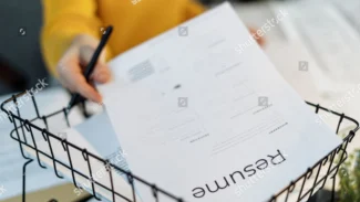 a person holding a pen and cv in a basket
