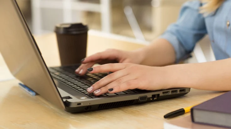 a woman using a laptop computer on a table
