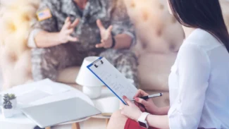 a woman sitting on a couch interviewing a soldier