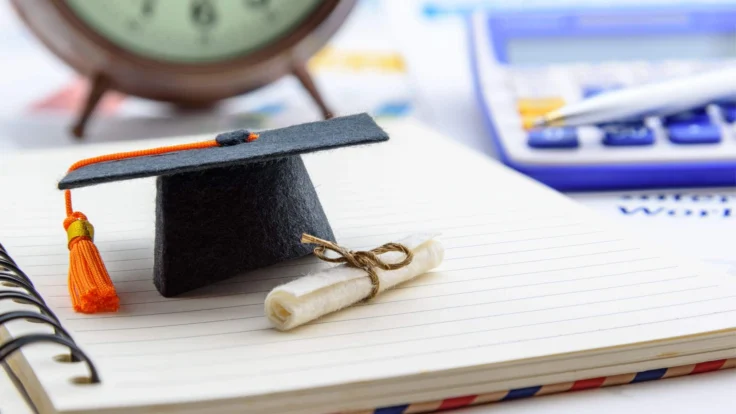 a graduation cap and tassel on top of a notebook