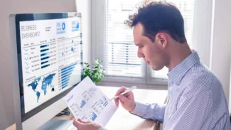 a man sitting at a desk in front of a computer.