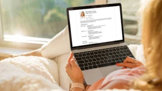a woman sitting on a couch using a laptop computer.