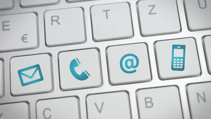 a close up of a keyboard with a phone and email.