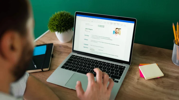 a man sitting in front of a laptop computer doing his cv
