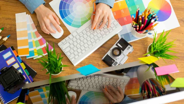 a person using a computer on a wooden desk.
