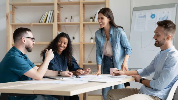 a group of people sitting around a table listening to a communicator