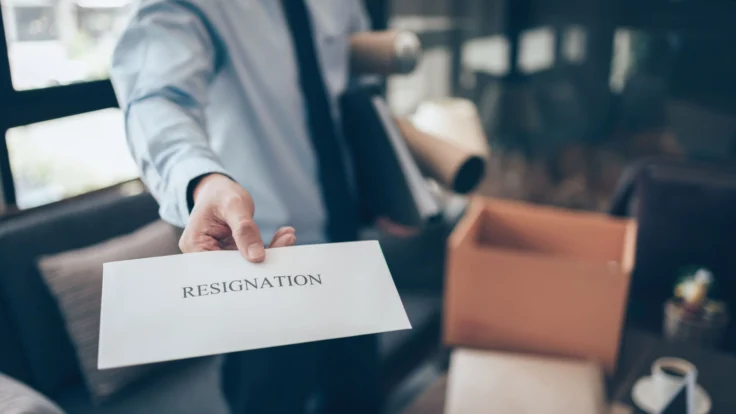 a man holding a resignation envelope