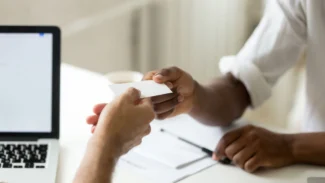 a person handing another person a business card.
