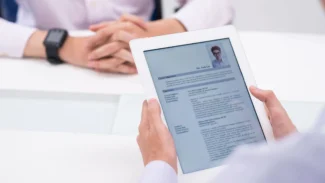 a person sitting at a table holding a tablet.